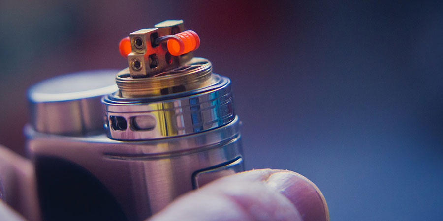 close up view of a hand holding a vape device